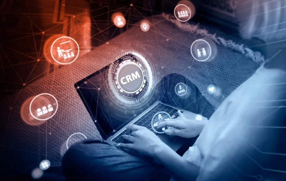 Dealership salesperson using automotive CRM software on a laptop